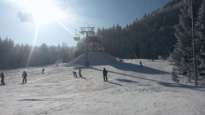 Lyžiari na svahu SKI Králiky, sedačková lanovka v nízkom slnku.